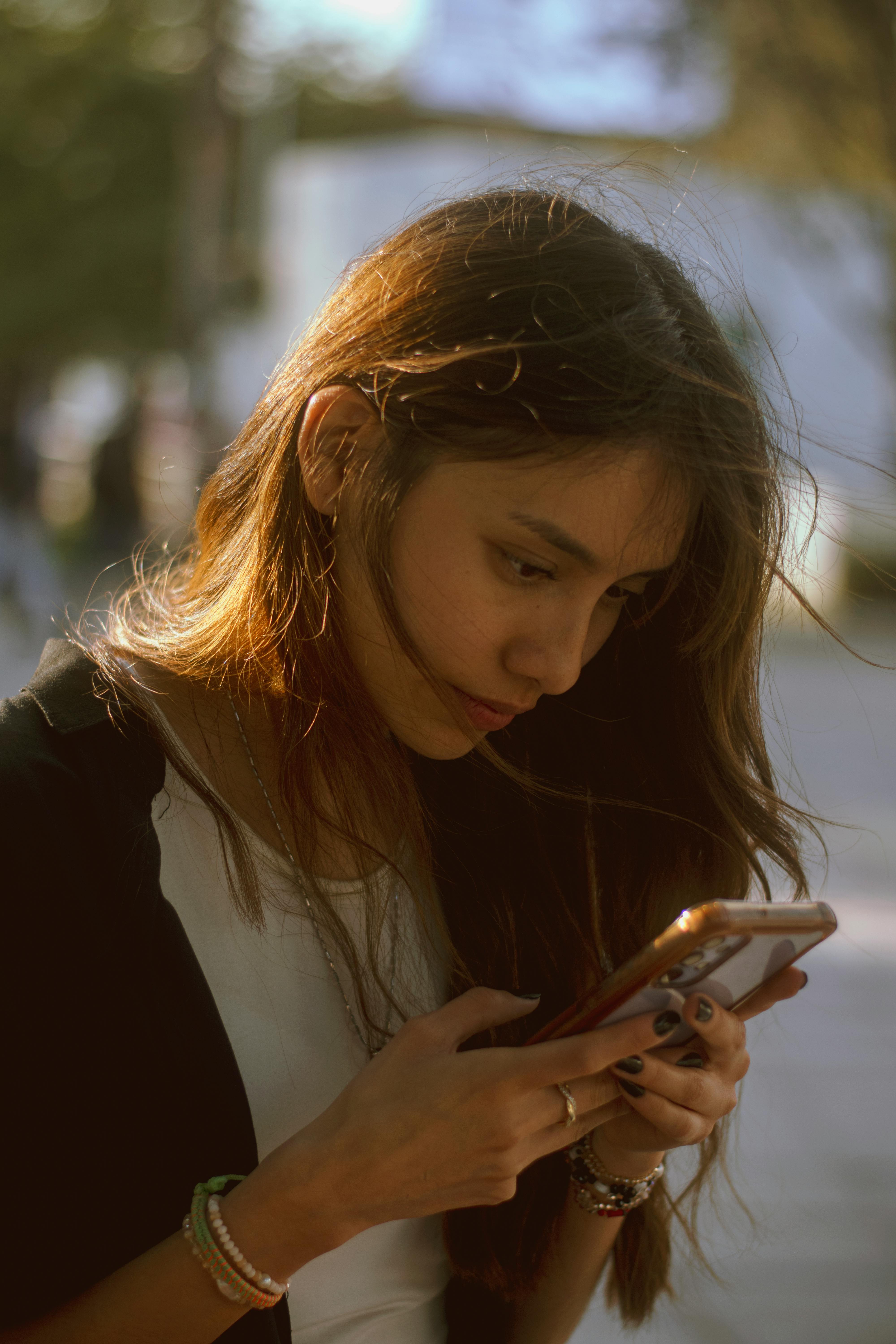 Joven cliente Renova consultando su celular al atardecer